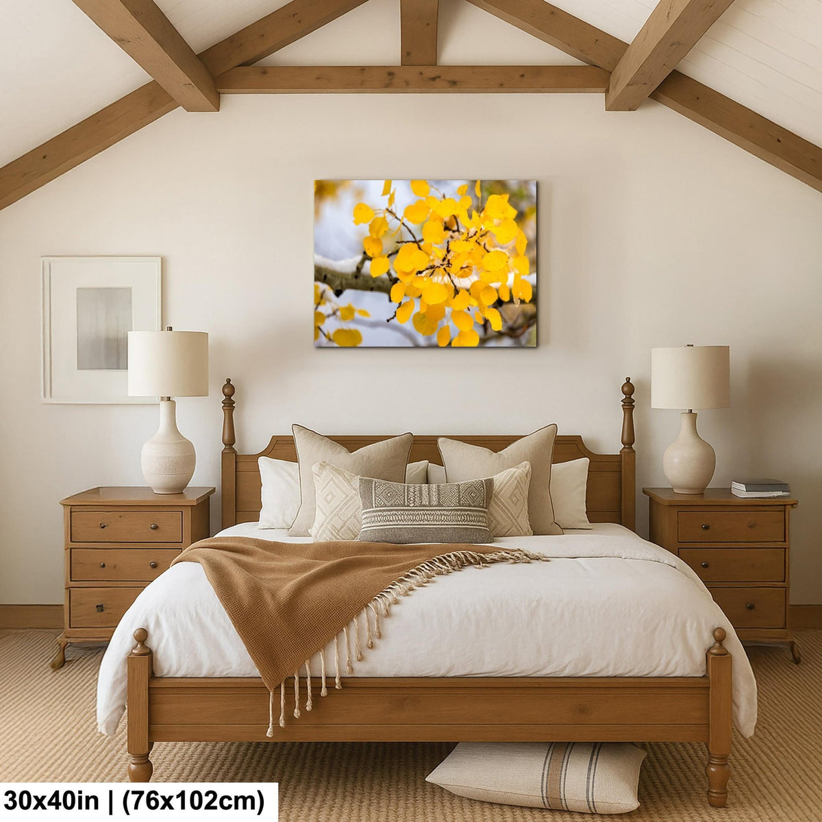 a cozy bedroom with a large bed, wooden furniture, and a framed picture of a tree with yellow leaves hanging on the wall.