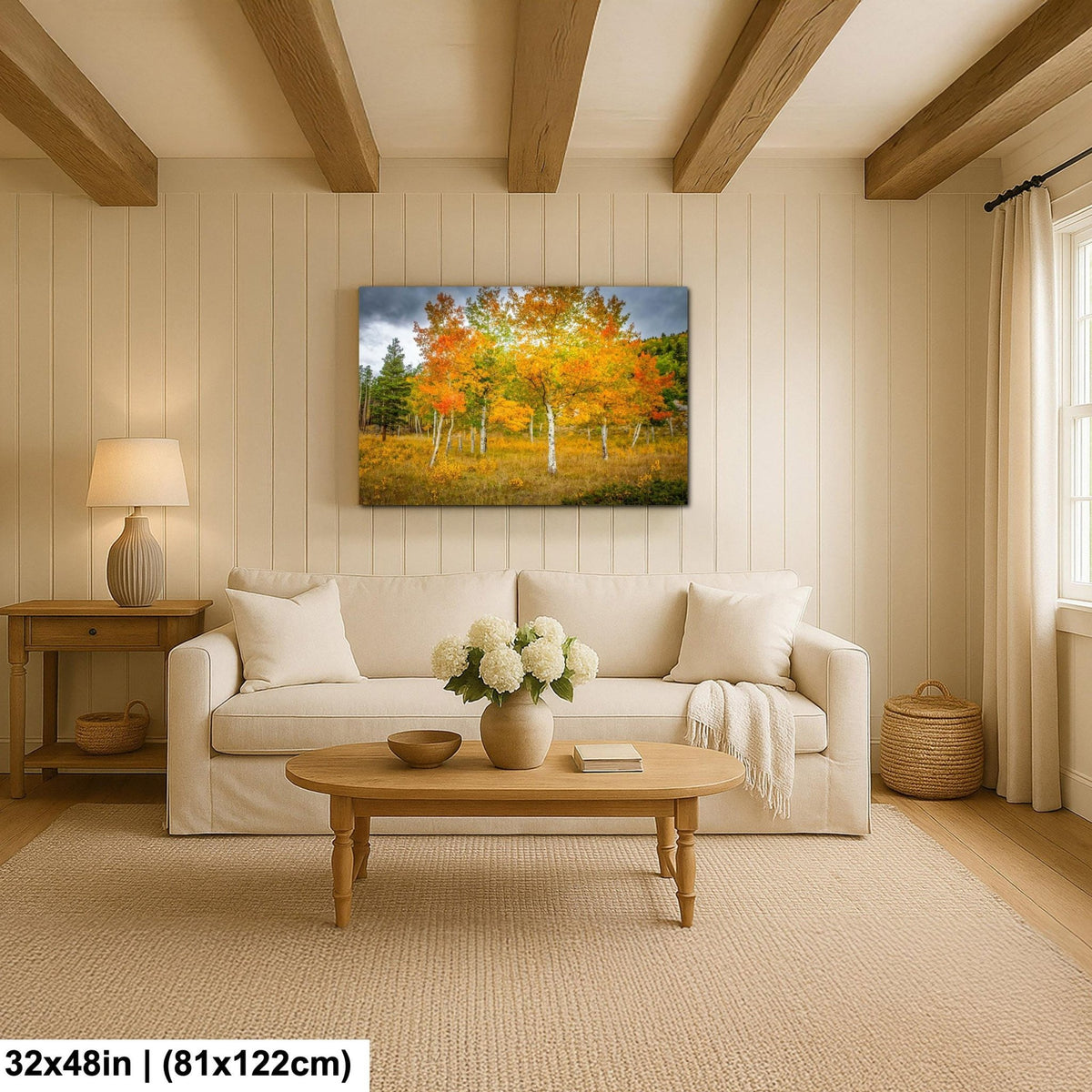 a cozy living room with a large, vibrant painting of a forest scene hanging on the wall above a white sofa. The sofa is positioned in front of a wooden coffee table, which has a vase of white flowers on it. The room also features a wooden side table with a lamp, and a woven basket on the floor. The overall atmosphere of the room is warm and inviting, with the painting serving as a focal point.