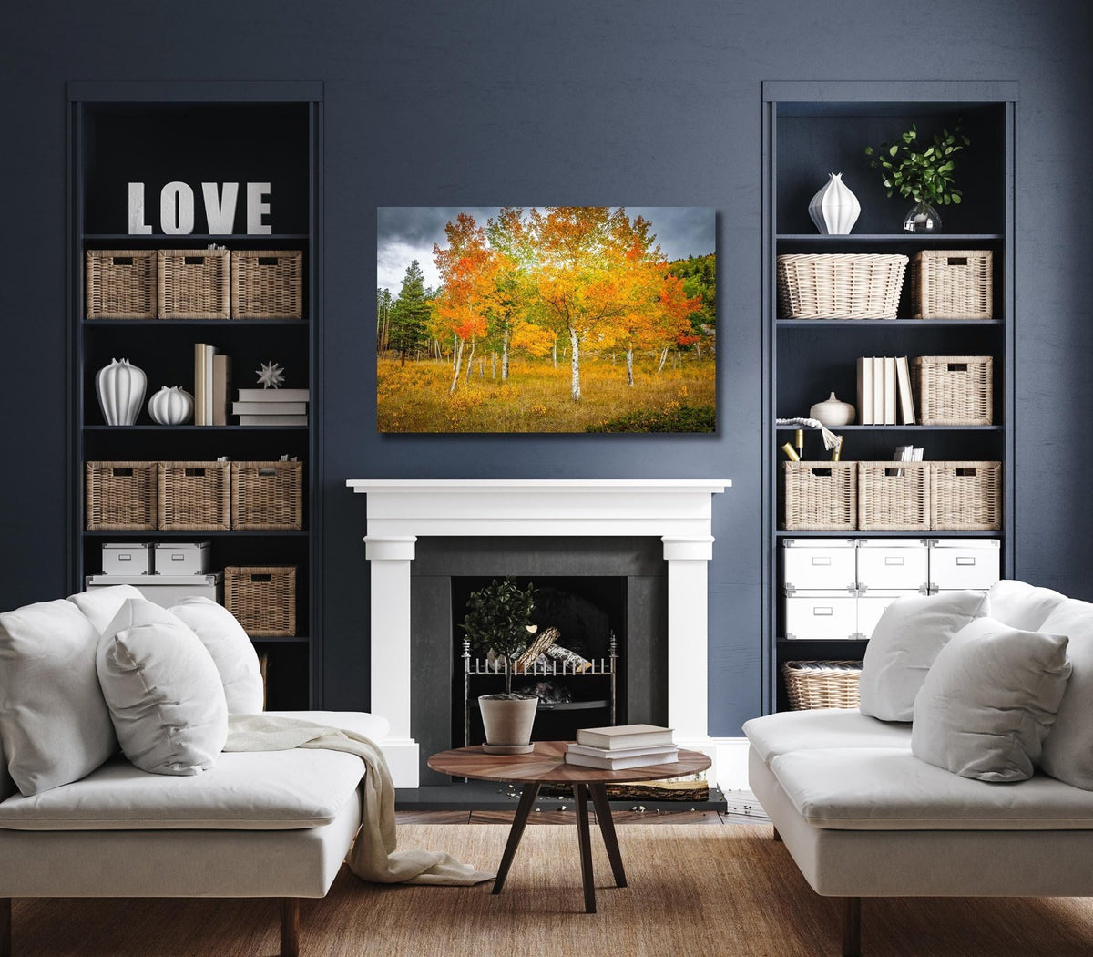 a cozy living room with a fireplace, white sofas, and a bookshelf filled with various items. The focal point of the room is a large painting of a tree with vibrant autumn foliage.