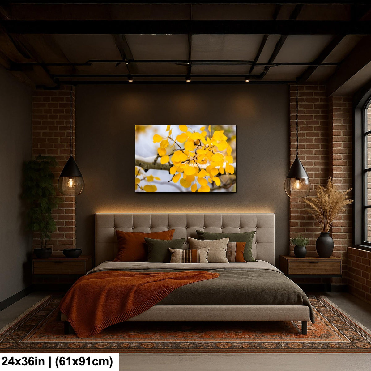 a cozy bedroom with a large bed, a brick wall, and a painting of yellow leaves hanging above it.