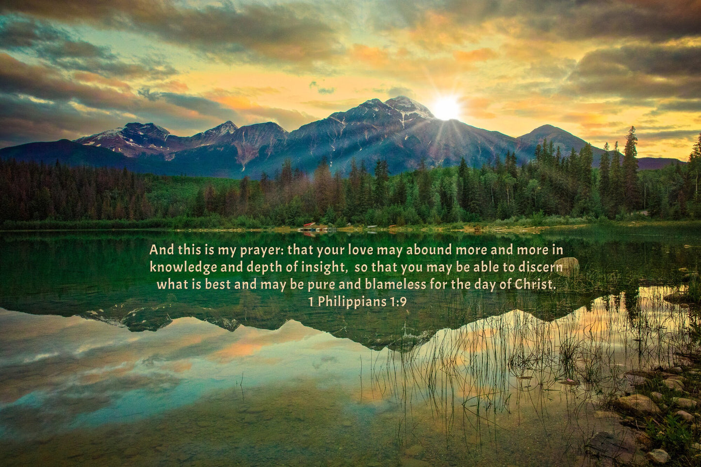 Beautiful sunrise photo in Jasper, Canada. The sunrise coming over the mountain is creating a beautiful reflection in the lake. The verse 1 Philippians 1:9 is showing over the water.