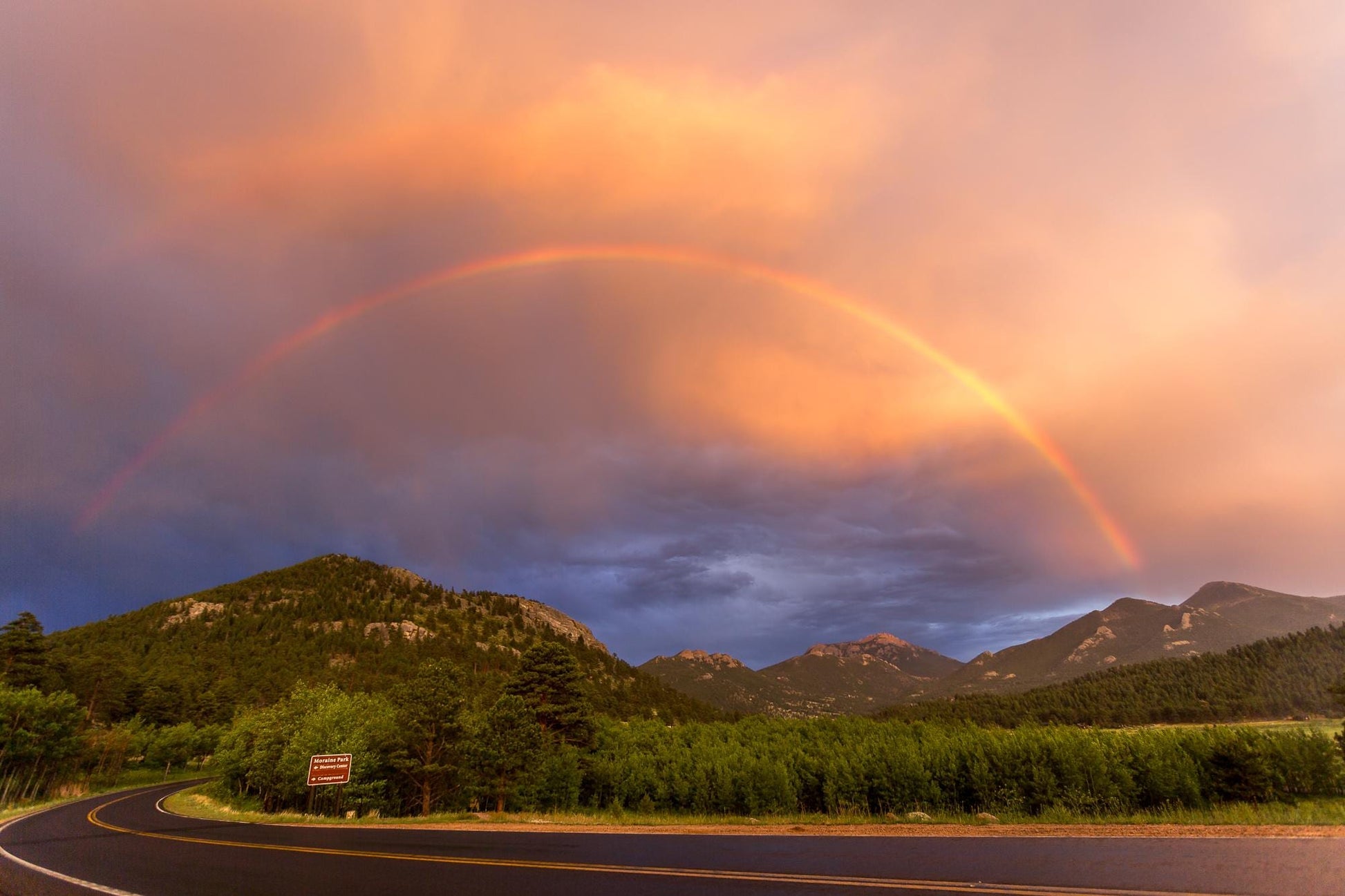 Rainbow over Moraine Park in Rocky Mountain National Park. Beautiful stormy sky with blues and orange clouds and a rainbow running through. Available in prints - paper, canvas, metal and acrylic.