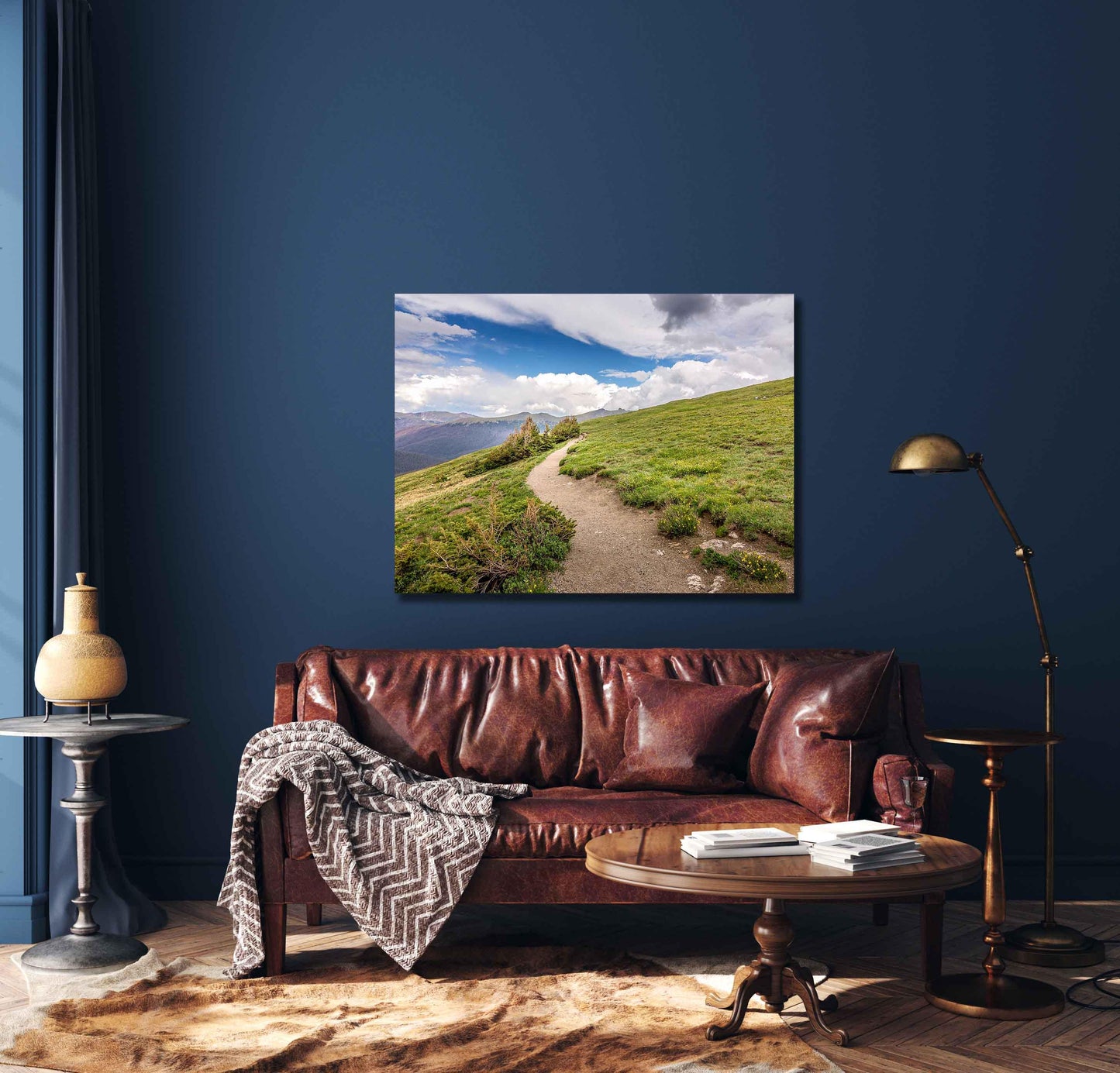 Canvas print of hiking trail on the tundra at 10,000 feet up. Mountain Trail going into the clouds on Trail Ridge Road in Rocky Mountain National Park, Colorado. Mockup showing canvas hanging on a dark blue wall over a leather couch.