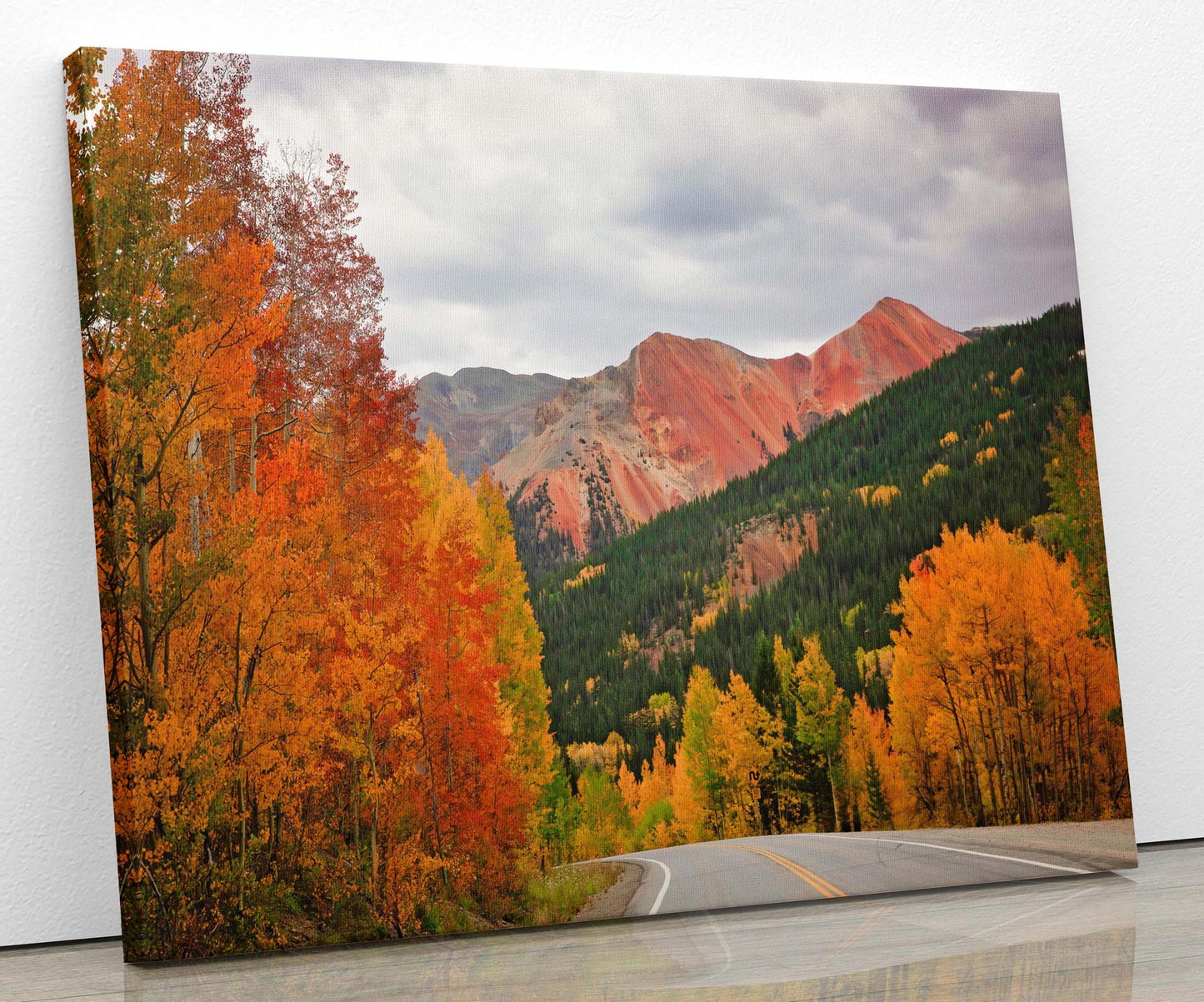 Red and orange aspens under red mountain peaks on the Million Dollar highway in fall, near Ouray and Silverton Colorado