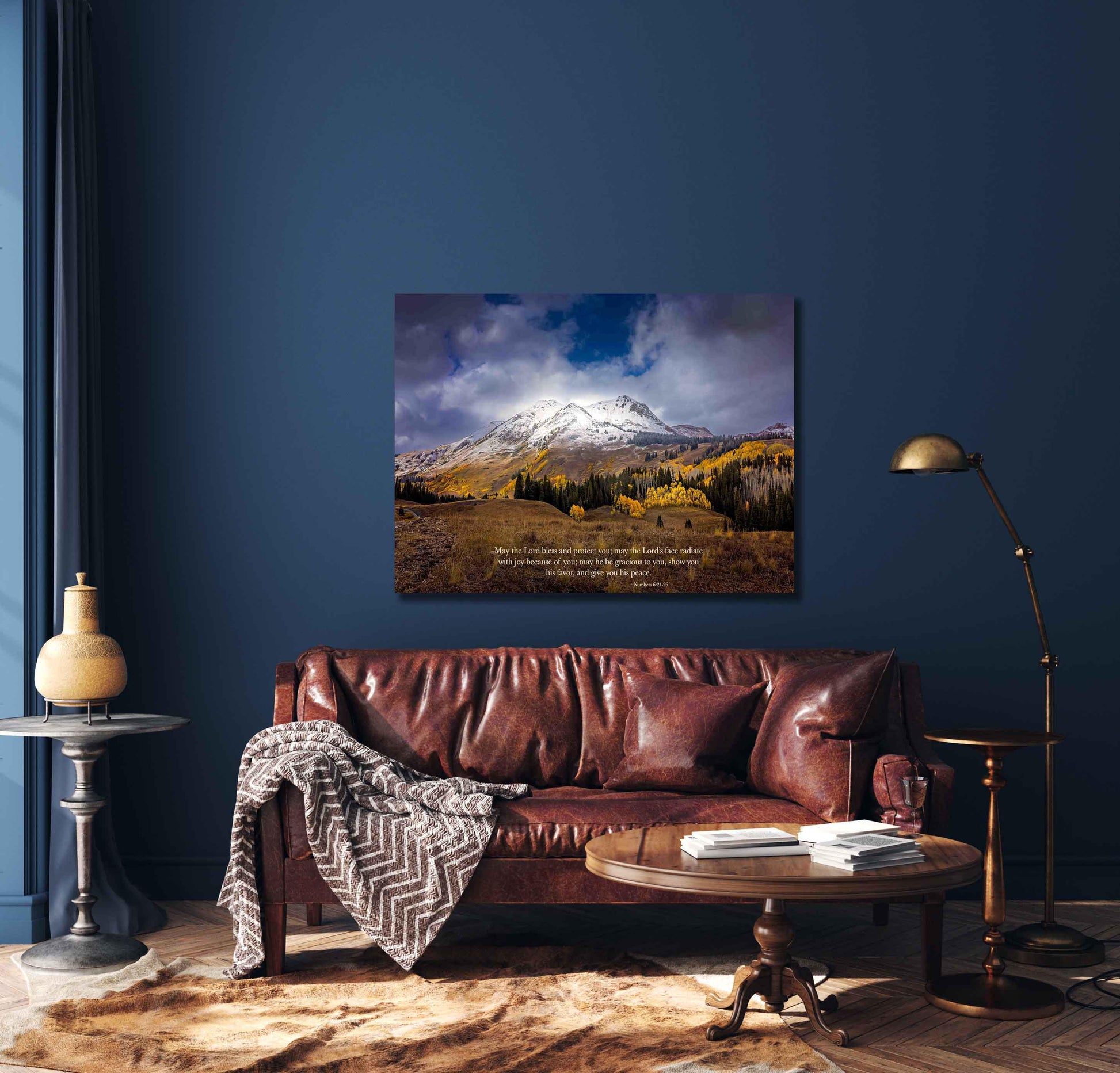 Numbers 6:24-26 verse on background of snowy mountain peak soaring over golden fall aspens in Colorado. Photo shows image printed on canvas. Shown over a leather couch on a navy wall