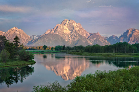 Beautiful purple and blue sky sunrise over the Grant Teton mountains with reflection in the water. GRAND TETON National Park, Wyoming. Available in canvas and print for home or office decor.