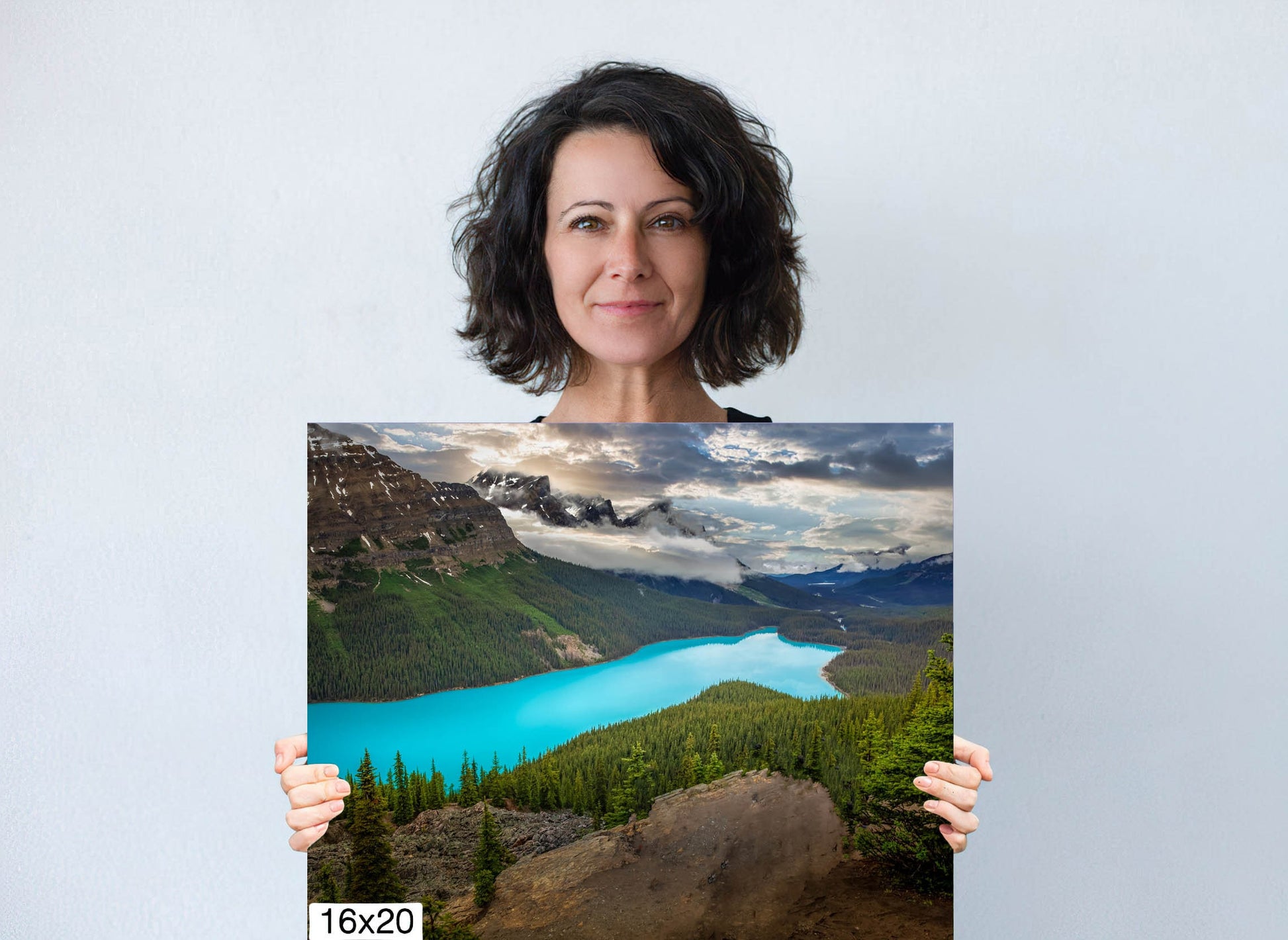 Woman holding a 16x20 caverns print of Peyto Lake in the Canadian Rockies. Shaped like a wolf, Peyto Lake has beautiful turquoise color. Beautiful wall decor for home or office. Available in canvas or paper print.