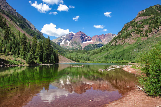 Beautiful blue skies with soft clouds over the Maroon Bells peaks in the Rocky Mountains, Colorado.